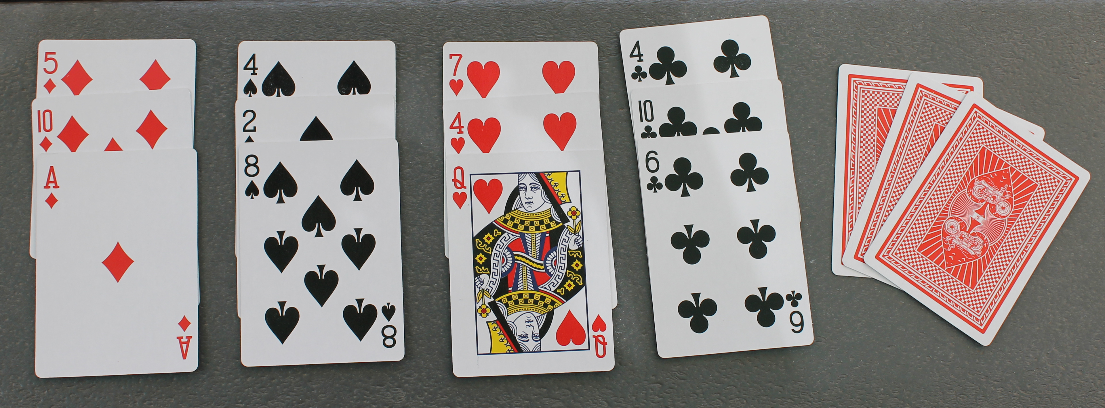 Fifteen playing cards, three diamonds, three spades, three hearts, three clubs, three facedown.