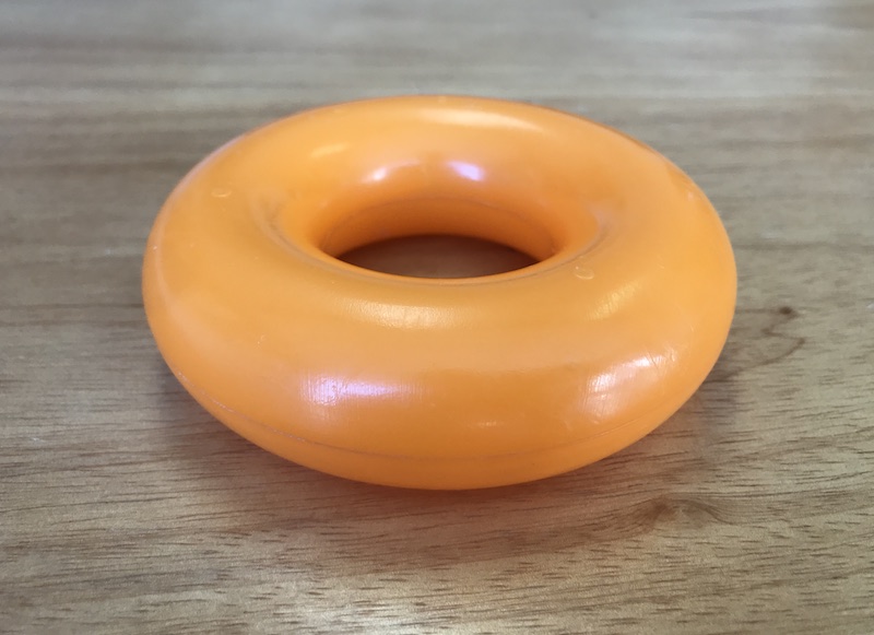 orange stacking ring toy resting on a wood table