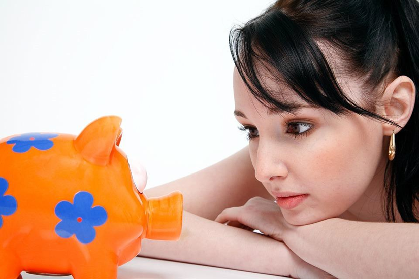 Photo of Woman Looking at Piggy Bank