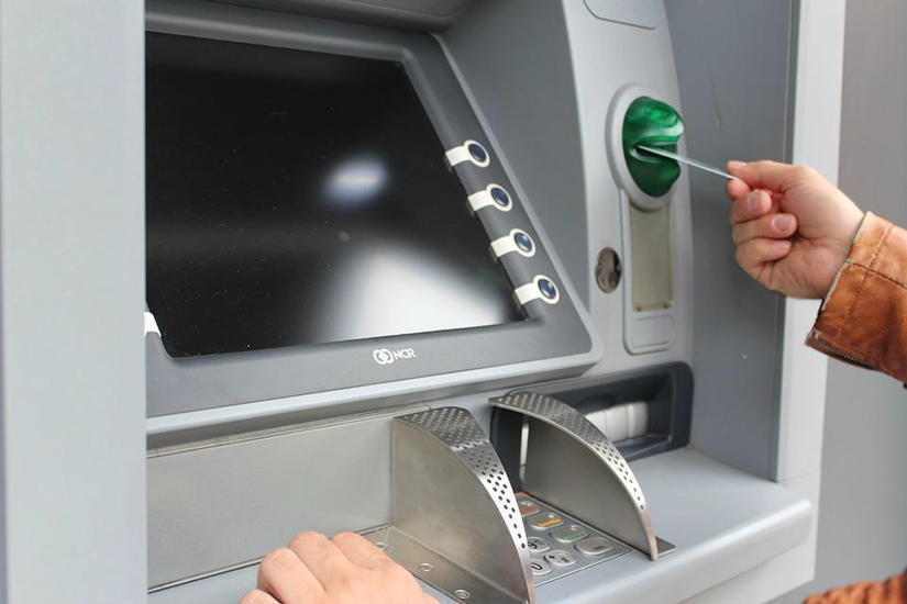 Image of a Person Inserting Debit Card in an ATM